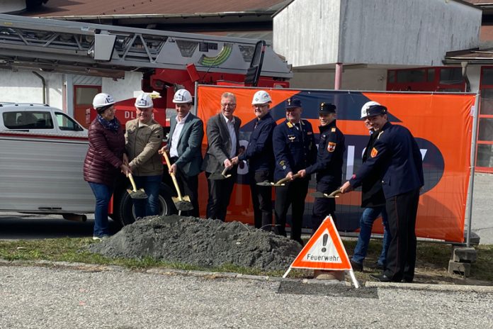 Frauen, Männer und Arnoldsteiner FF-Jugendliche verfolgen interessiert den Spatenstichs.